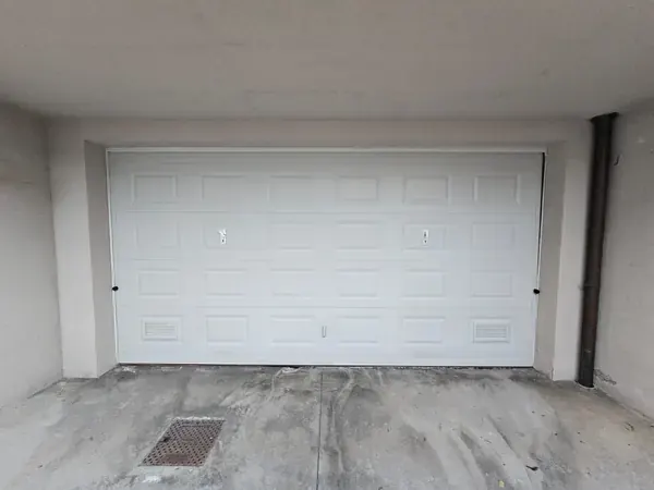 Porta sezionale bianca di un garage doppio – riparazione serrande a Padova