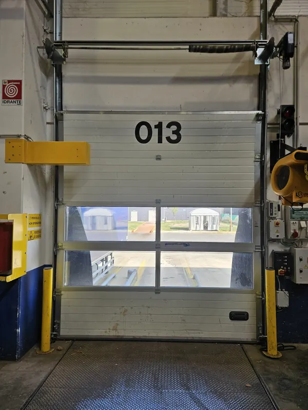 Porta sezionale industriale con finestrature su una baia di carico – riparazione serrande a Padova